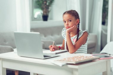 İlgisiz yorgun küçük memnun Olmayan Afro-Amerikan kız dizüstü bilgisayarda oturan