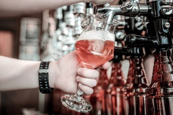 Bartenders handen vullen een glas met bier van de tap. — Stockfoto