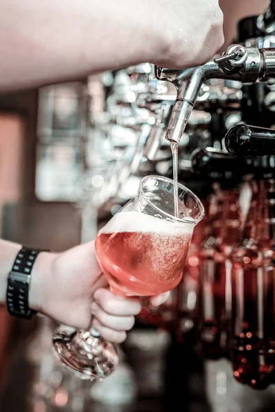 Atento ao dever barman derramando cerveja em um copo . — Fotografia de Stock