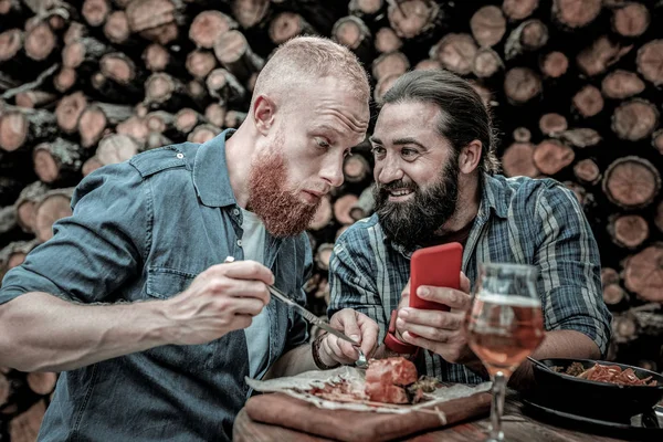 Amigos comiendo juntos frente a la leña . — Foto de Stock