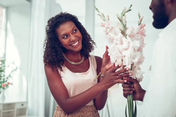 Gülümseyen koyu saçlı Afro-Amerikan kadın kocasından çiçek alan — Stok fotoğraf