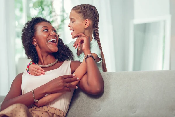 Encantadora madre compartiendo una risa con una linda hija alegre —  Fotos de Stock
