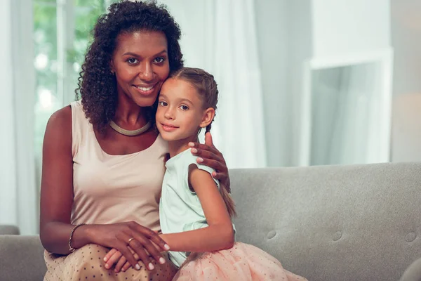 Sierlijke vrouw omarmen mooi mooi meisje met vlechten — Stockfoto