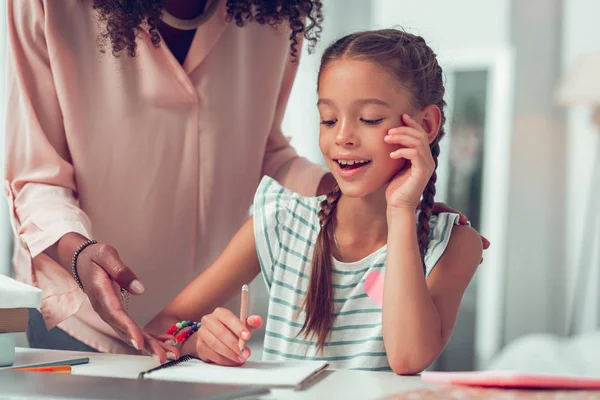 Enfant mignon demandant de l'aide à la mère concernant les devoirs de l'école . — Photo