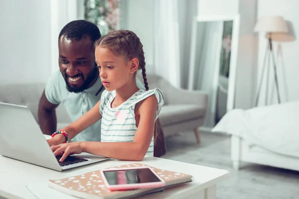 Focalizzato afro-americano ragazza con trecce digitando su una tastiera del computer portatile — Foto Stock