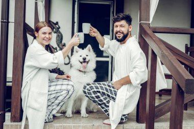 Contended neşeli orta yetişkin karı koca sabah kahve kupaları clinking