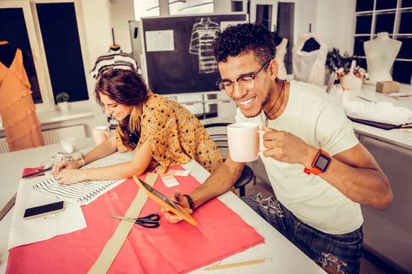 Fröhliche Schneiderinnen, die im Atelier arbeiten und lachen. — Stockfoto