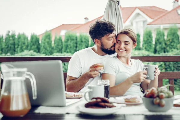 有吸引力的丈夫亲吻他的妻子在花园里吃早餐 — 图库照片