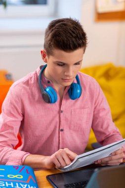 Matematik ödevi yapan boynunda kulaklık takan öğrencinin yakın çekim