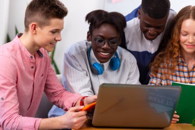 Arkadaşlarıyla konuşurken gülen koyu tenli genç