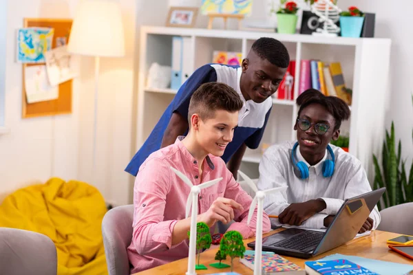 Tres estudiantes viendo la lección de ecología y estudiando juntos —  Fotos de Stock