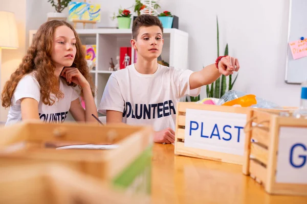 Krullend meisje toetreden haar beste vriend terwijl het sorteren van afval samen — Stockfoto