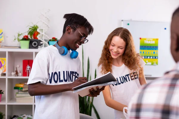 Adolescentes fazendo anotações depois de classificar pouco na organização voluntária — Fotografia de Stock