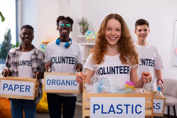 Meisje Holding doos met plastic na het sorteren van afval met vrienden — Stockfoto