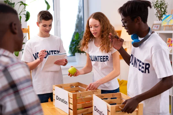 Tieners zetten voedsel voor donatie in dozen samen — Stockfoto