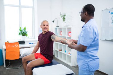 Spor yaralanma rehabilitasyonu olan kolunda dövme olan sporcu