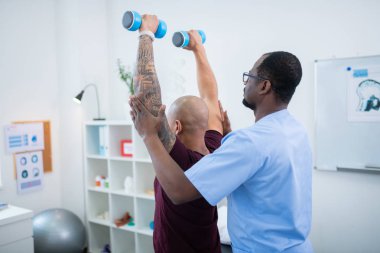 Barbells ile egzersiz yaparken kol kaldırma elleri dövme ile Adam