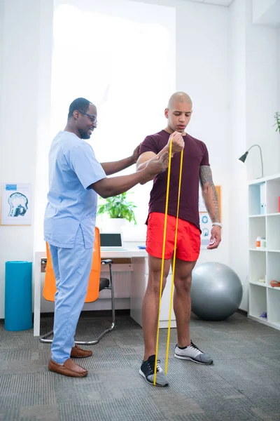 Спортивний терапевт допомагає пацієнту виконувати вправи на руки — стокове фото