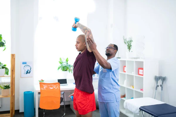 Темношкірий терапевт, який працює зі спортсменом після серйозних травм — стокове фото