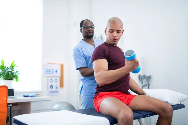 Sportovec staví svaly v blízkosti fyzikální terapie — Stock fotografie