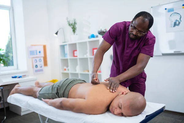 Темношкірий масажист використовує кулаки під час масажу — стокове фото