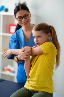 Kararlı uzun saçlı kız sarı t-shirt aktif elleri germe