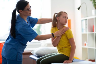 Özel hareketler sunan mavi üniformalı koyu saçlı doktor