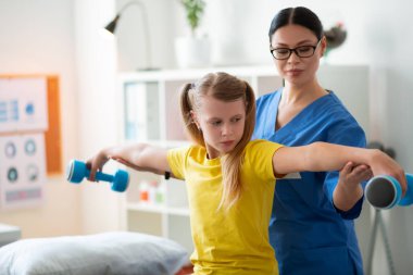 Serpişme elleriyle gündüz yatağında oturan ciddi genç bayan