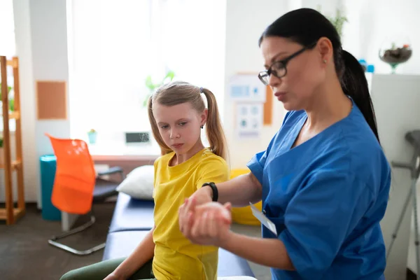 Fokuserad långhårig asiatisk medicinsk arbetare undersöker läkningsprocessen — Stockfoto