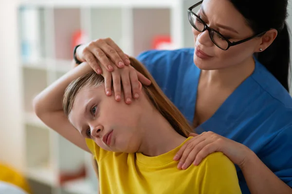 Noggrann mörkhåriga asiatiska läkare stretching nackmusklerna — Stockfoto