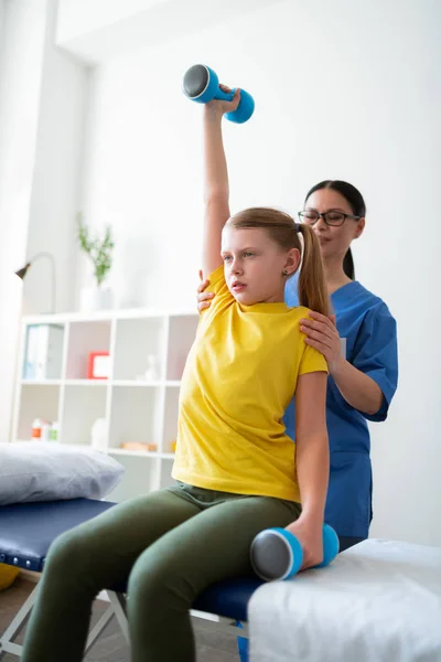 Tranquillo ragazza ben educata che trasporta attrezzature sportive pesanti — Foto Stock