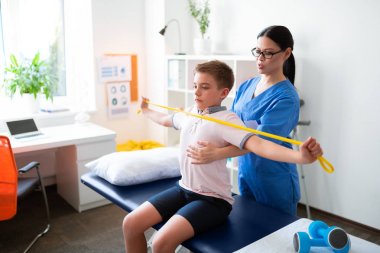 Profesyonel fizyoterapist nazikçe prosedür ile küçük çocuk yardım