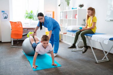 Gri pilates topuna yaslanan çalışkan küçük çocuk