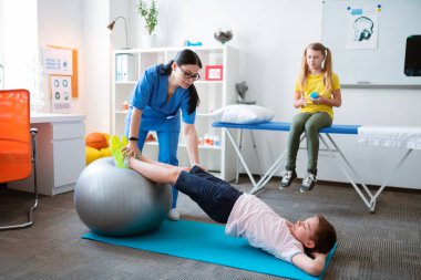 Pilates topuna yaslanarak tüm vücudu geren aktif küçük hasta