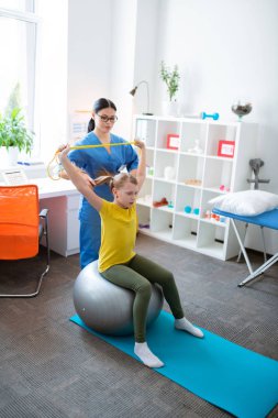 Deneyimli Asya fizyoterapist farklı araç ve ekipman kullanarak