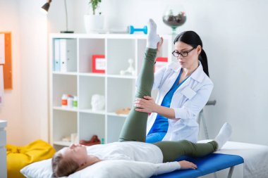 Beyaz cüppe bacak yükselterek Deneyimli Asyalı doktor