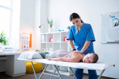 Mavi üniforma presleme yetenekli uzun saçlı Asya masöz