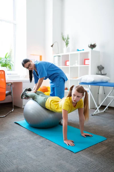Gri Pilates topuna yaslanan doğru çalışkan kız — Stok fotoğraf