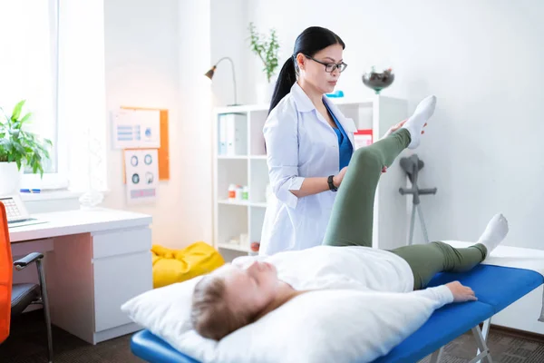 Gefocust langharige fysiotherapeut betrokken bij de examenprocedure — Stockfoto