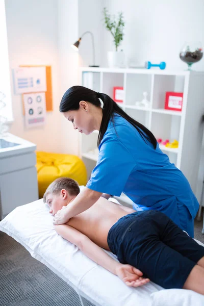 Ervaren Aziatische meester wrijven schouders van naakte jongen — Stockfoto