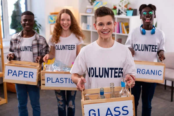 Stilig tonåring hållande låda med glasflaskor efter sortering — Stockfoto