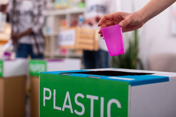 Chica poniendo vidrio rosa en la caja con residuos de clasificación de plástico —  Fotos de Stock