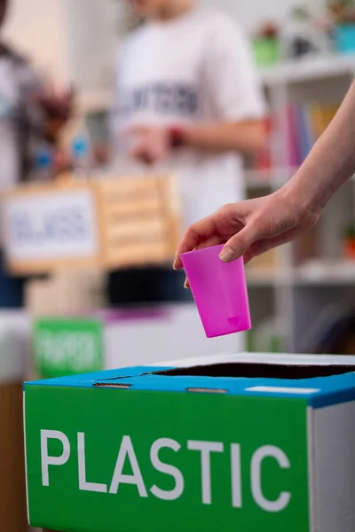 Meisje putting Roze plastic Cup in vak tijdens het sorteren van afval — Stockfoto