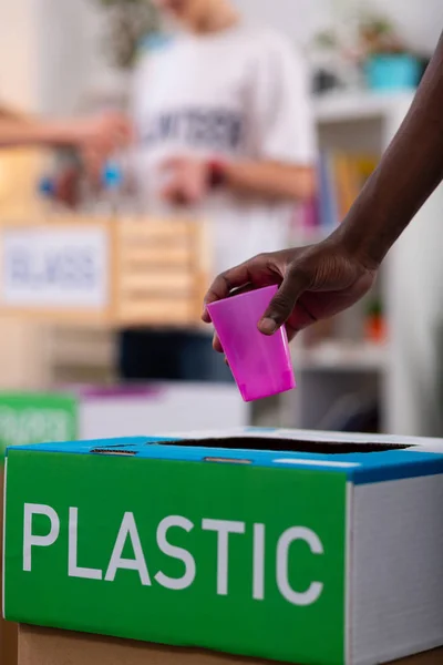 Jongen putting Roze plastic Cup in vak tijdens het sorteren van afval — Stockfoto