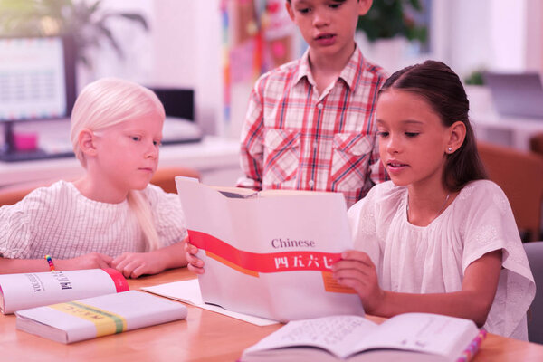 Three concentrated children learning chinese at school.