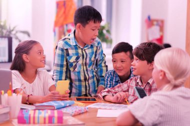 Mutlu çocuklar okulda gülüyor ve şakalaşıyor.