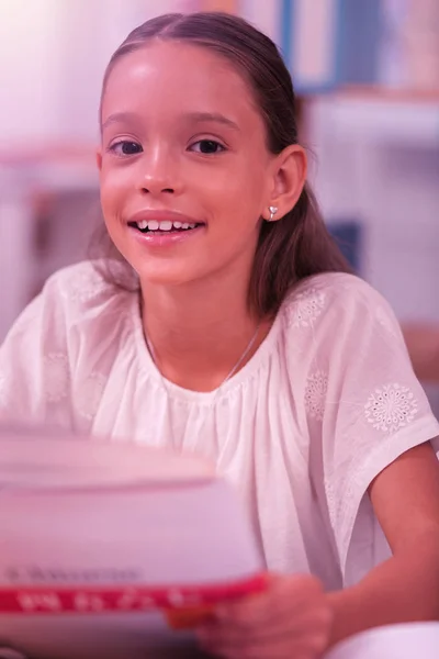 Sorrindo menina sentada na mesa da escola . — Fotografia de Stock