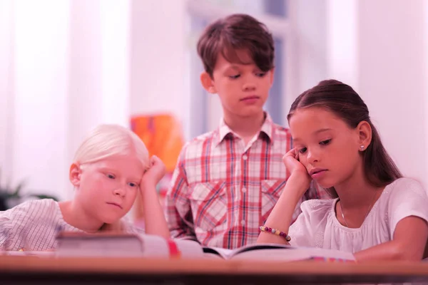 Enfants dans une classe essayant de lire le livre . — Photo