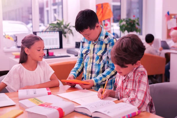 Tre alunni che lavorano insieme ai compiti . — Foto Stock