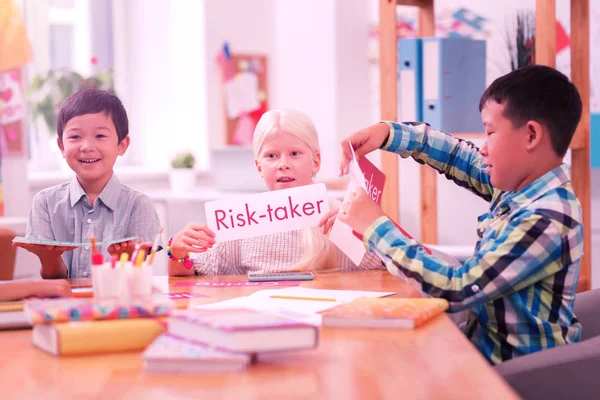 Niños leyendo palabras en inglés de hojas de papel . — Foto de Stock